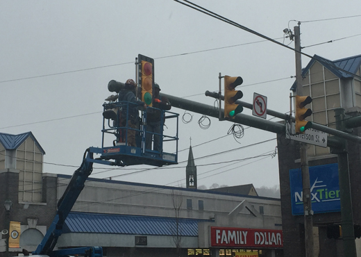 Technicians install new traffic lights on new poles at the intersection of Market and Jefferson streets in downtown Kittanning last week.