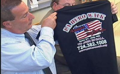 Al Pulice shows Armstrong County commissioners teeshirt for PA Hero Walk.