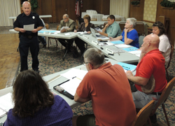 Officer-in-Charge Greenlee gives the August police report during the beginning of last night's meeting.