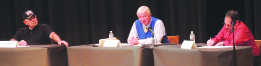 Stan Buggy (left) and Tony DeLoreto (right) listen while Don White answers a question during last Tuesday's debate at West Shamokin High School. It was attended by less than 50 people.