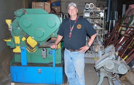 Operator Chad Potensky stands in front of a 100-ton iron worker machine that shears, bends, punches holes in all types of metal including angle iron. It is for fabrication of heavy metal with assorted dyes. The machine was imported from Europe.