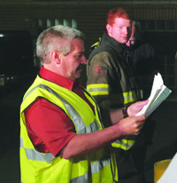 Armstrong County Disaster Drill Coordinator Bill Hamilton reviews evaluation sheets submitted by emergency response team members.