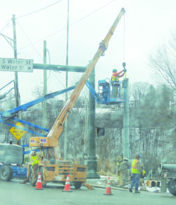 Construction crews work on traffic signals at the corner of Market Street and Water Street Thursday morning.