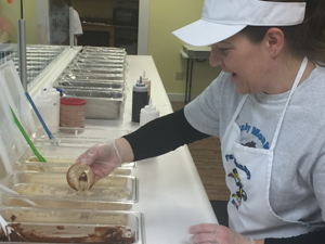 Donut designer Barb Goldinger customizes a personalized creation for her customer at the Funky Monkey.